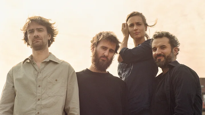 Nevermind quartett: Four people stand outdoors in the sunlight for a photo. They are wearing casual clothing and looking at the camera.